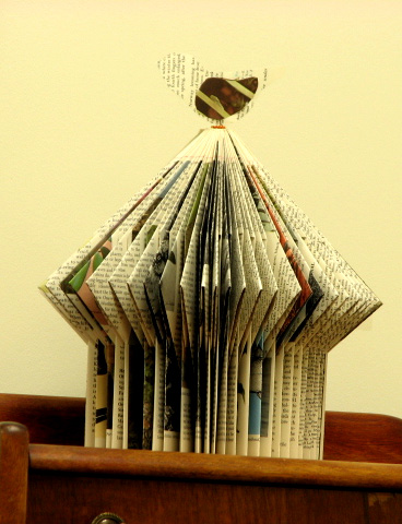 E. Talmage repurposes old books into paper sculptures, like this birdhouse from an old Audubon encyclopedia.