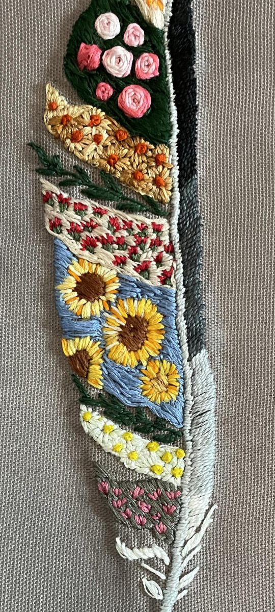 Feather embroidered with many colors, textures, and flowers, on a neutral background fabric. Art © copyright Rebecca Padula, shown here by permission.