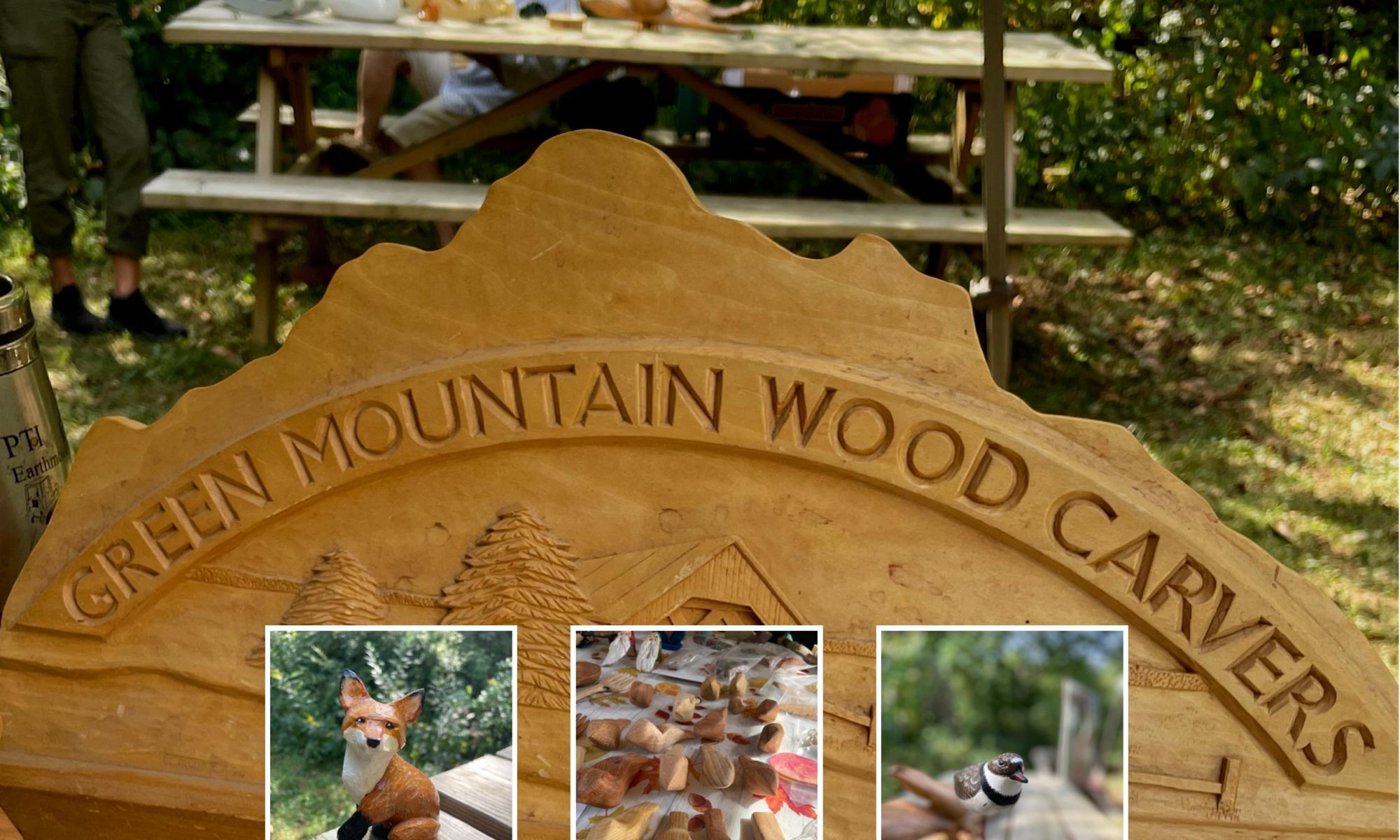 A bas-relief carving of the Green Mountain Woodcarvers logo (their name in arched letters against a mountain ridgeline over a covered bridge and some evergreen trees) rests on a picnic table; two people converse in the background at another table with woodcarvings on it. Three images are inset: a carved and painted seated fox looking over its shoulder with one paw raised; many carved "comfort birds" in different types of wood; a killdeer painted "smoothie" carving on a single dowel base.